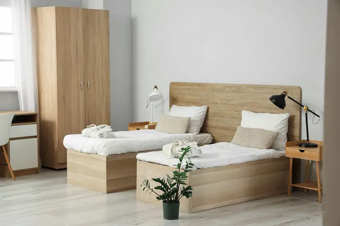 Chambre moderne avec deux lits simples, ambiance chaleureuse qui reflète le confort attendu dans une résidence de tourisme pour des vacances réussies.